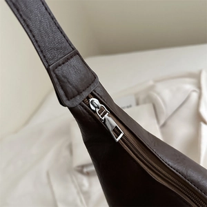 Dark brown leather tote bag with silver zipper and refined stitching detail for women