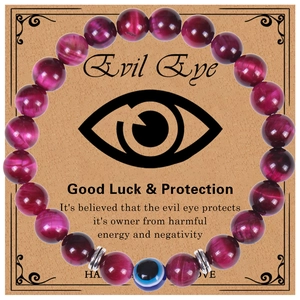 Detail eines rosa Katzenaugen-Armbands mit Evil Eye-Anhänger auf einer Geschenkkarte