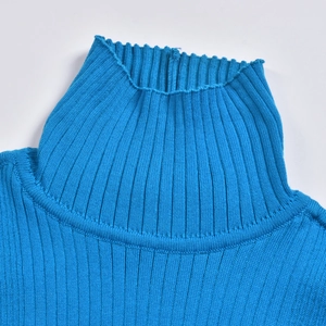 Gros plan sur le col roulé bleu montrant la texture en maille côtelée verticale et souple
