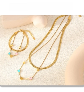 Detail of PVD gold double-layer necklace and bracelet set with colorful heart pendants
