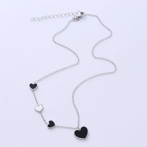 Elegant stainless steel necklace with four black and white heart pendants on an O-chain