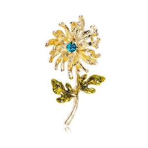 Close-up of golden floral brooch with green enamel leaves and blue crystal center