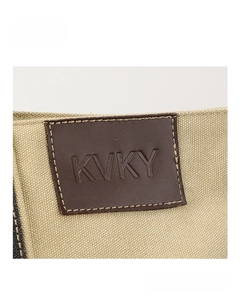 Detail des auf der beigen Canvas-Schultertasche aufgenähten KVKY-Lederlogos