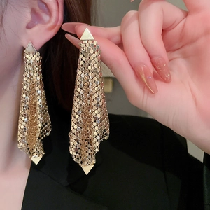 Golden fringe earrings with metal mesh weaving and triangular accents on model