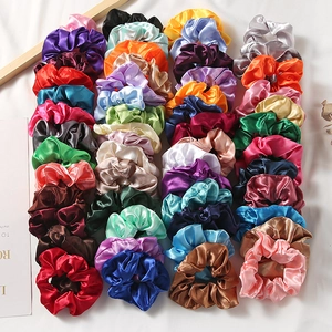 Colorful satin silk scrunchies set in various vibrant shades on a white background