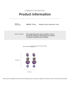 Macro view of vintage cat earrings with purple resin stone, rhinestones and size details