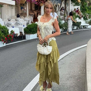 Close-up of cream lace camisole with ruffles and olive green tiered chiffon maxi skirt