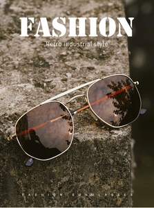 Retro industrial gold metal pilot sunglasses with brown lenses on a concrete texture