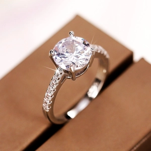 Macro view of four-prong set round zircon engagement ring with a micro-pave band
