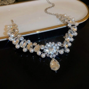 Elegant pearl and crystal floral necklace with pear-shaped drops on luxury tray