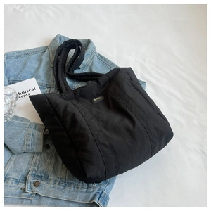 Detailed view of the black quilted puffer tote bag with lightweight nylon fabric