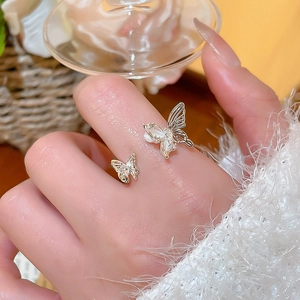 Detail of elegant butterfly ring with white cat eye stones and sparkling crystals