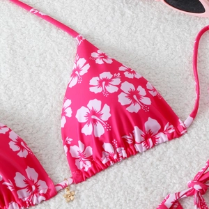 Detail of pink floral bikini top with hibiscus print and small golden flower charm