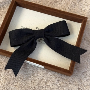 Detailed view of the black knit bow hairclip with premium ribbed fabric texture