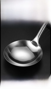 Close-up of polished stainless steel ice clip with smooth edges and deep scoop design