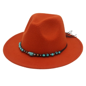 Close-up of orange felt fedora with ornate beaded band and blue gemstone detail