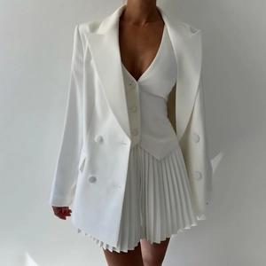 Détail de l'ensemble gilet blanc à col en V et jupe plissée avec blazer ajusté