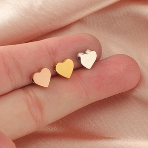 Polished heart-shaped stainless steel beads in rose gold, gold and silver on fingers