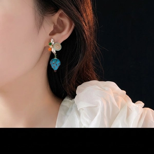 Vintage blue strawberry drop earrings with colorful crystals on a model side view