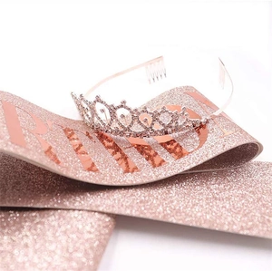 Close-up of sparkling silver rhinestone crown and rose gold glitter Bride sash set