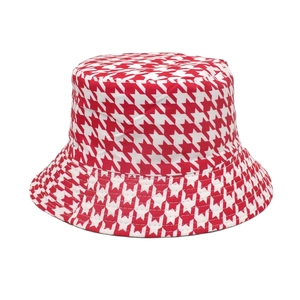 Close-up detail of the classic red and white houndstooth pattern on a summer bucket hat