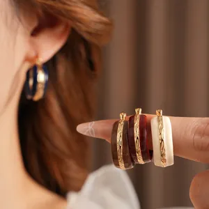 Vintage enamel C-shaped hoop earrings with gold floral relief in four classic colors