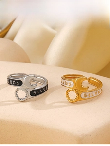 Detail view of wrench-shaped rings with drip oil finish and engraved text on silk