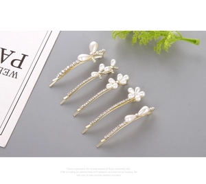 Detailed view of 5-piece gold hair clip set with white pearls and rhinestones
