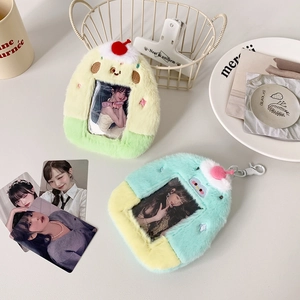 Detail of plush monster photocard holders with cherry decor in green and blue colors