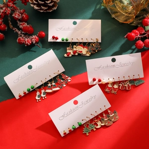 Detail of Christmas earring set featuring Santa, snowmen, and reindeer on festive background