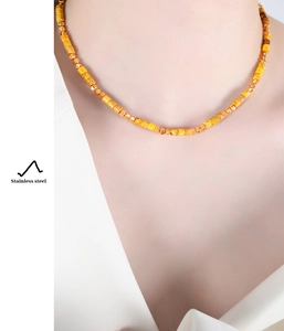 Detailansicht der gelben Steinperlenkette mit goldenen Trennperlen aus Edelstahl