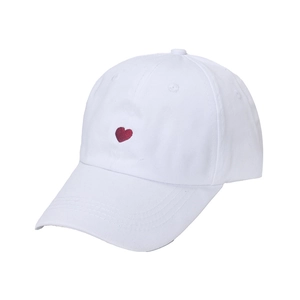 White cotton baseball cap with red embroidered heart design and curved brim for women