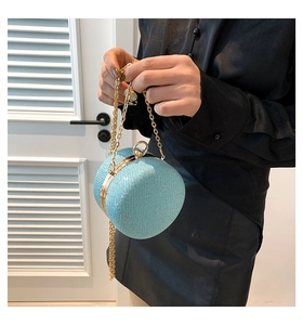 Detail of light blue glitter evening bag with gold metal frame and ring clasp