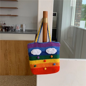 Close-up of handmade rainbow crochet tote bag with clouds and 3D colorful pompoms