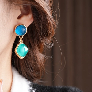 Gros plan de boucles d'oreilles vintage avec pierres rondes bleues et losanges verts
