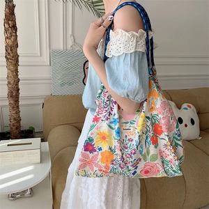 Floral tote bag with blue braided rope handles and vibrant colorful flower prints