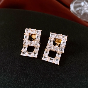 Vue macro de boucles d'oreilles rectangulaires évidées plaquées or avec zircons clairs