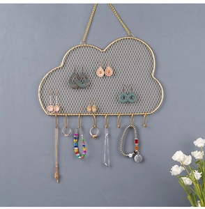 Detail of golden cloud-shaped jewelry organizer with metal mesh and eight hanging hooks