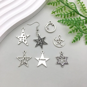 Flat lay of antique silver star and moon pendants with 'dream' engraving for DIY jewelry