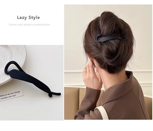 Detail view of a matte black twist hair clip in a lazy style geometric design