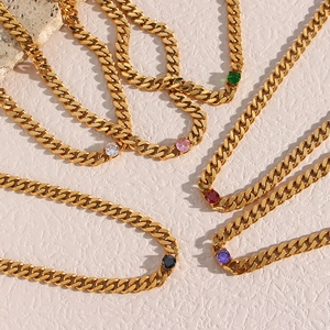 Detail of 18K gold plated Cuban chain necklaces featuring multicolored zircon stones