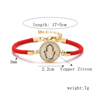 Macro view of red Milan rope bracelet with evil eye Hamsa hand charm and lobster clasp