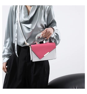Detailed view of unique silver-toned abstract metal handle on color-block crossbody bag