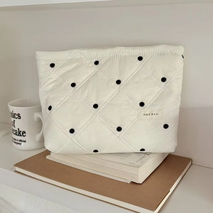 Vue détaillée de la trousse de maquillage blanche à pois avec étiquette en tissu