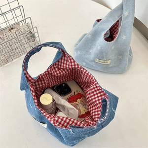 Detail of denim handbag with star pattern and contrasting red checkered fabric lining