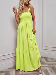 Detail of neon green maxi dress featuring ruched bust and adjustable tie straps