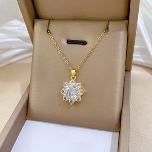 Detailed view of a gold flower pendant with sparkling zircons in a luxury jewelry box