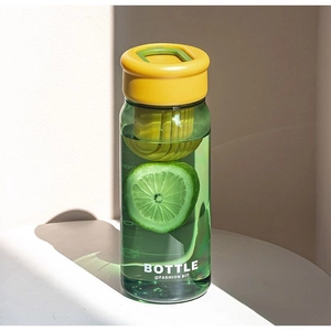 Macro shot of green plastic water bottle with yellow cap and built-in tea infuser filter