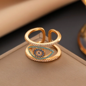 Detailed close-up of golden evil eye ring with blue and clear zircon stones in macro view