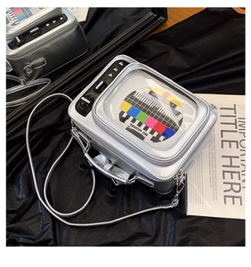 Close-up of silver TV-shaped crossbody bag with No Signal screen and heart stud details